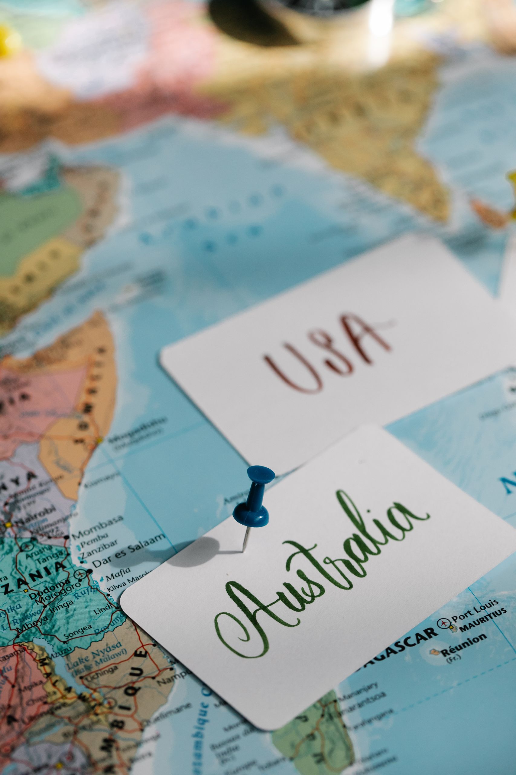Detailed close-up of a world map with USA and Australia labeled, highlighted with pins.